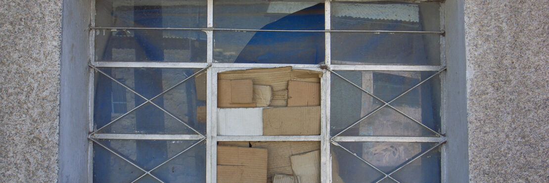 Image by Nicolas Nova - a broken window with cardboard over the missing pane