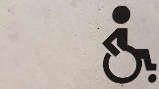 A wheelchair sign stencilled onto a wall